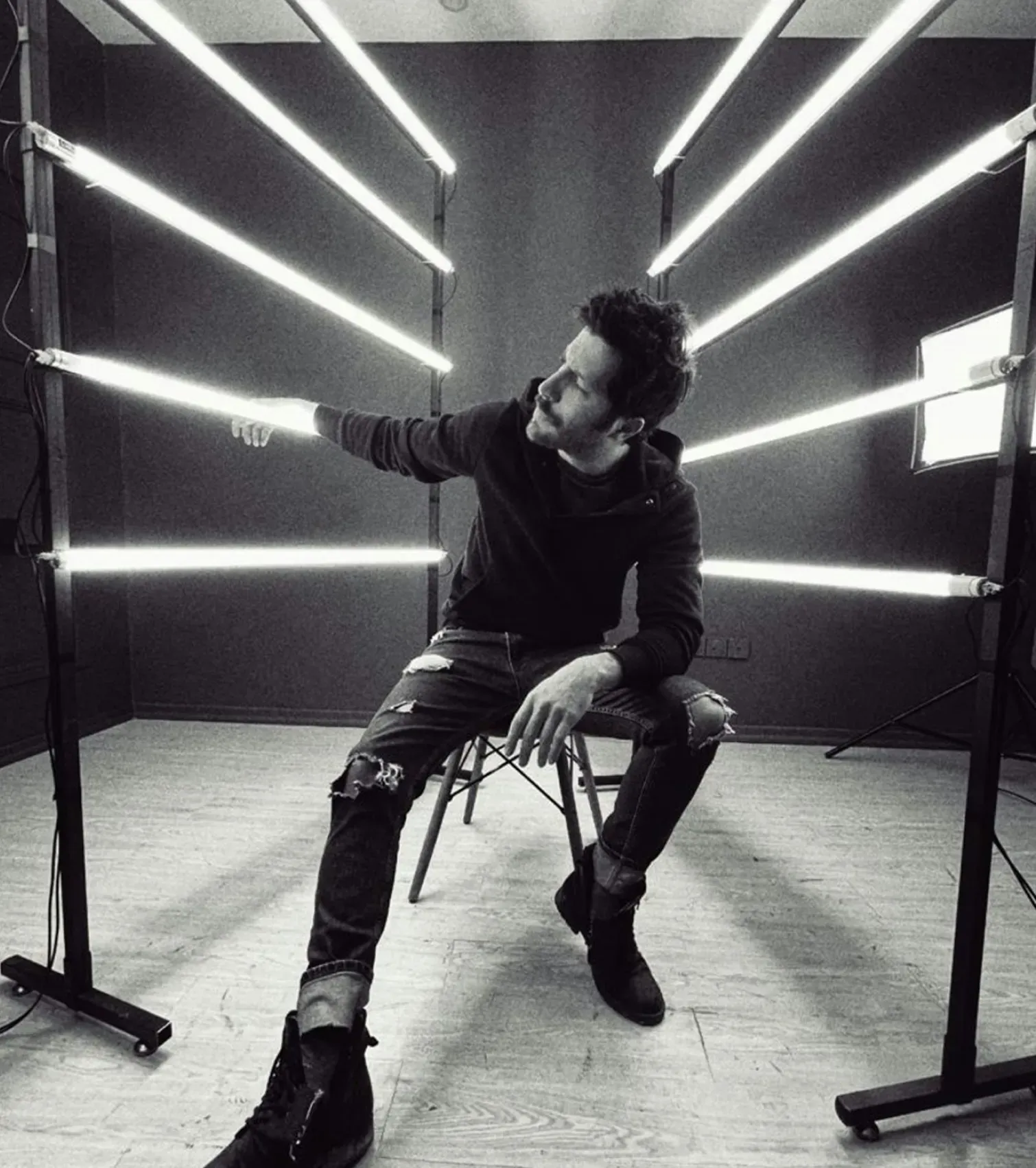 A photographer adjusting a light stand between frames