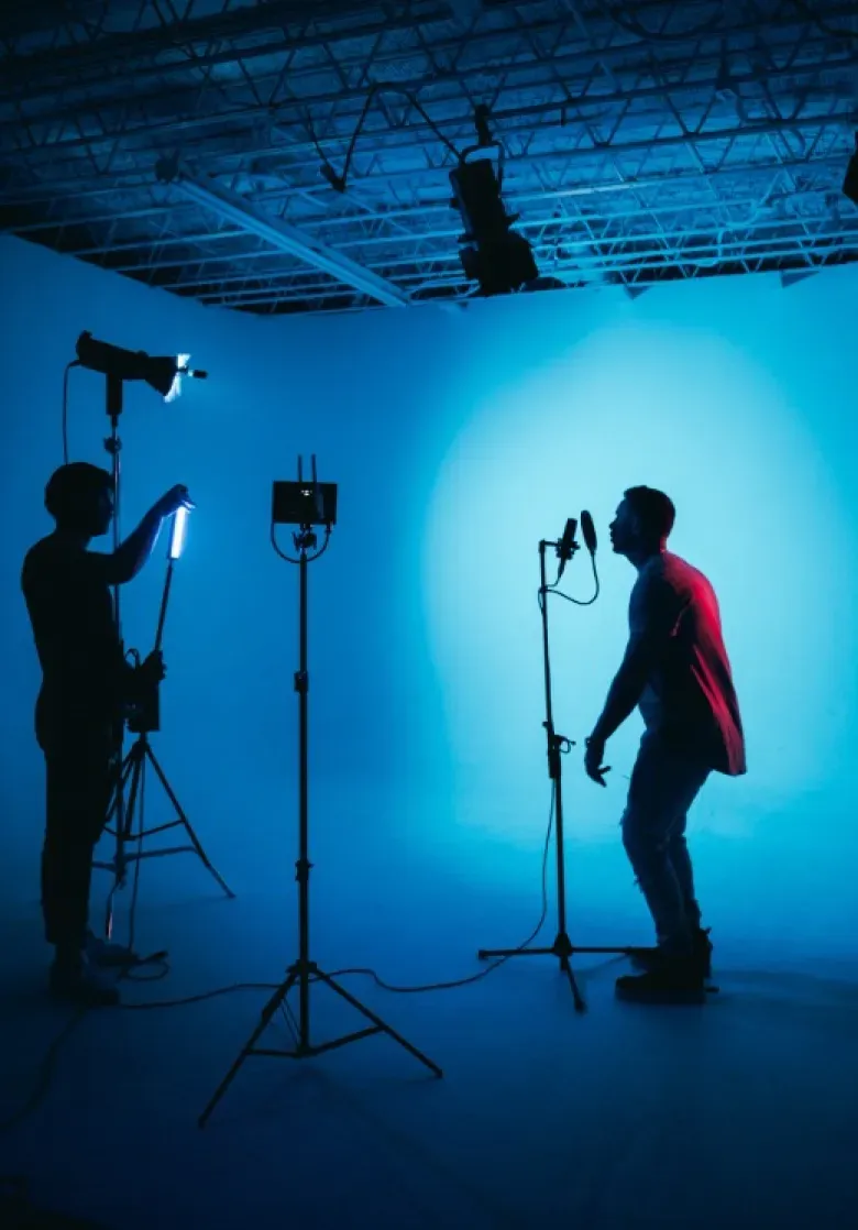 A musician being photographed against a lit cyclorama